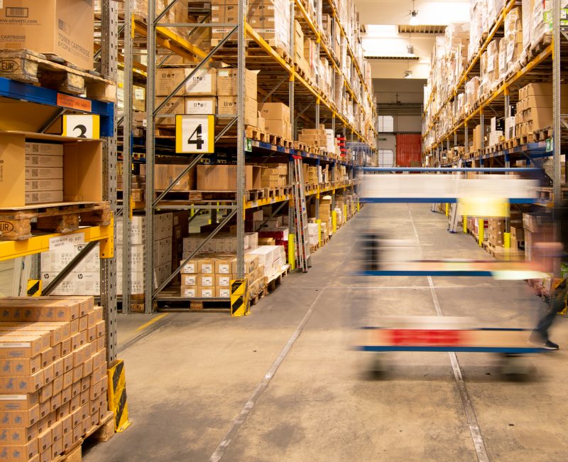 ein großes Lager, ein Mann fährt mit einem Wagen vorbei