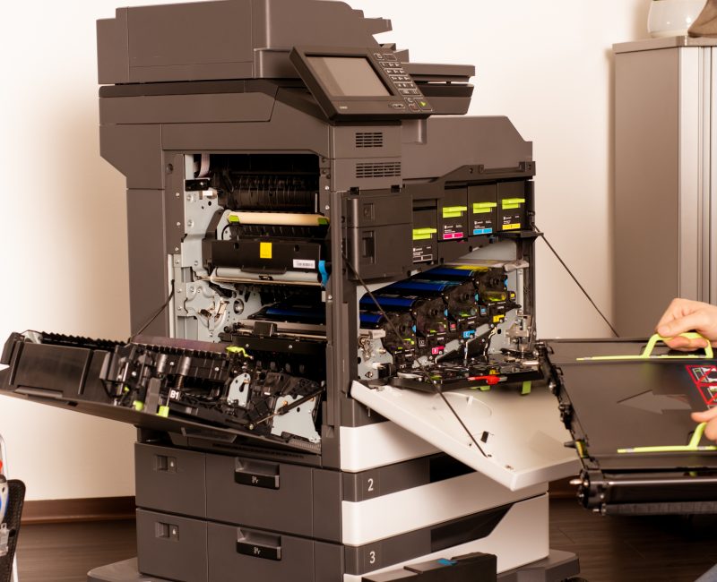 das Bild zeigt einen Techniker der an einem Kyocera Drucker arbeitet.