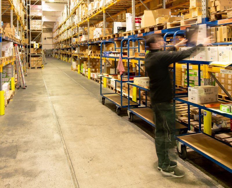 das Bild zeigt einen Mann bei der arbeit in einem großen Lager